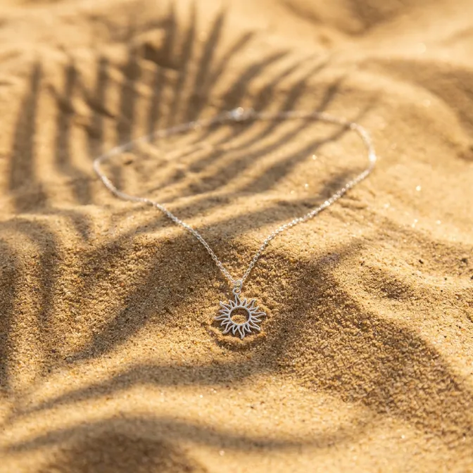 Silver necklace on golden sand